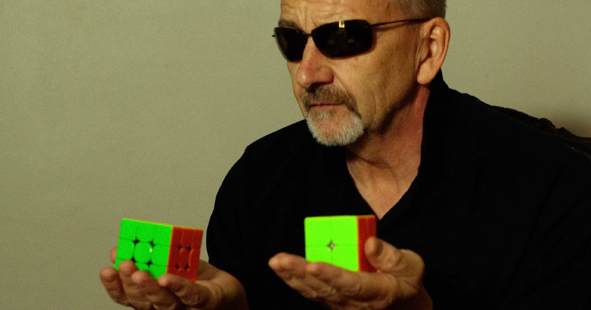 Man holding two Rubiks cubes